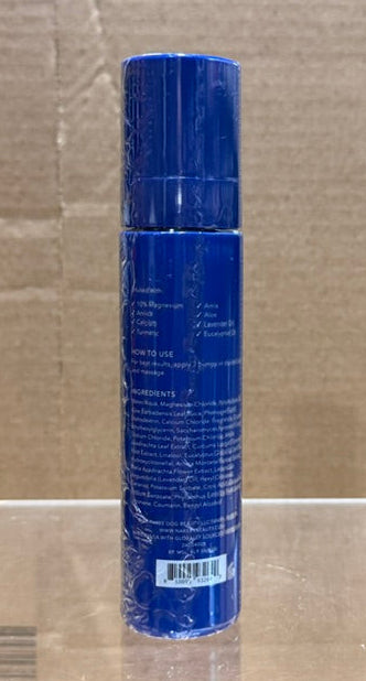 Back view of Nakery Skin Recovery Total Body Magic Spray, showing instructions and ingredients on a blue bottle.
